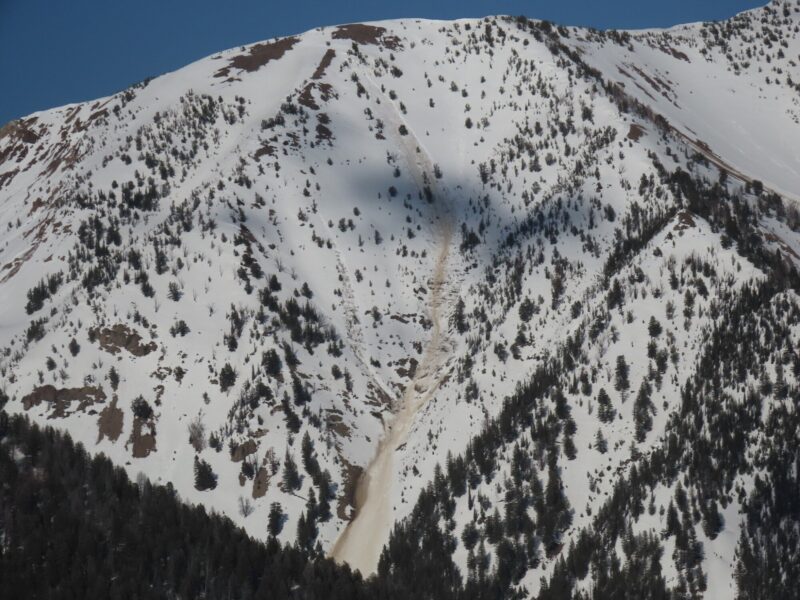 This large, gouging wet snow avalanche was observed in the Boulder Mountains on a SW-facing slope at 9,700'. It started at a point and quickly gouged through the wet snowpack to the ground, entraining significant amounts of snow, mud, dirt, and rock as it traveled downslope.